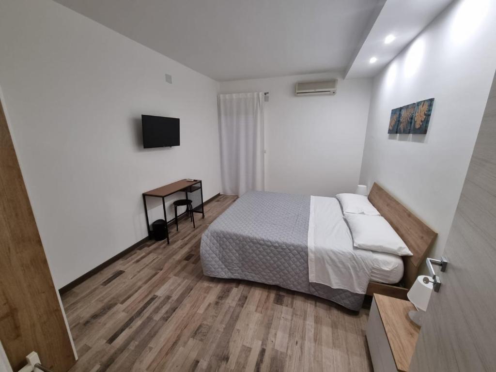 Dormitorio con cama, escritorio y TV en CIVICO 1, en Valguarnera Caropepe