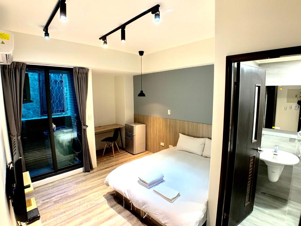 a bedroom with a bed and a sink in it at 台中 晴文旅 in Taichung