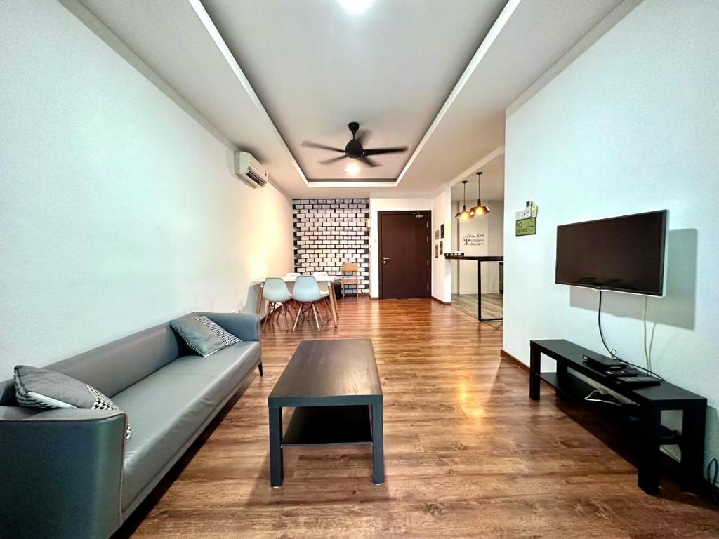een woonkamer met een bank en een tv bij CatCity Homestay - Viva Jazz Suites 1 in Kuching