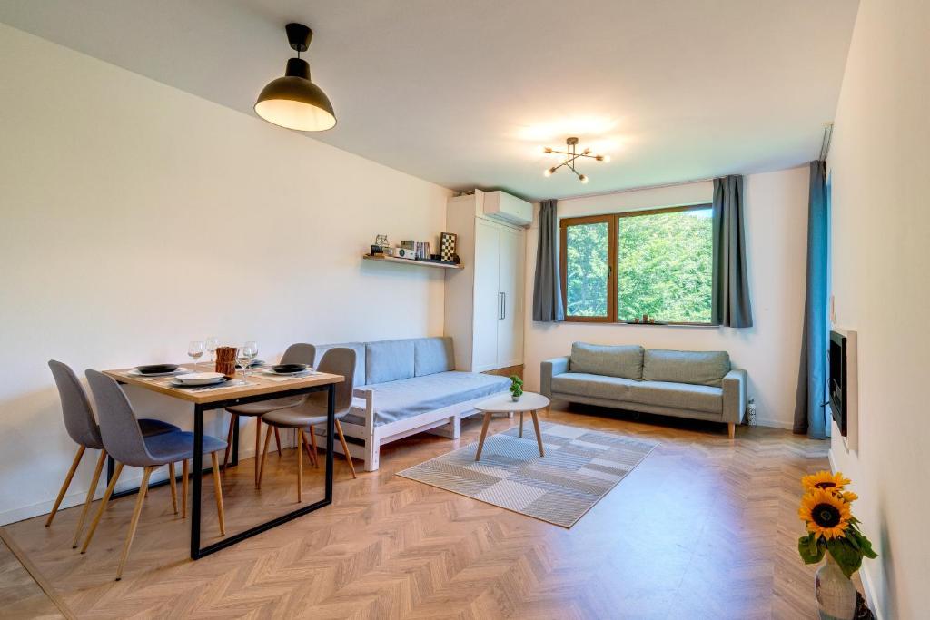 ein Wohnzimmer mit einem Tisch, Stühlen und einem Sofa in der Unterkunft Villa Kometa Pamporovo: Cozy 1-BD Flat in Pamporowo
