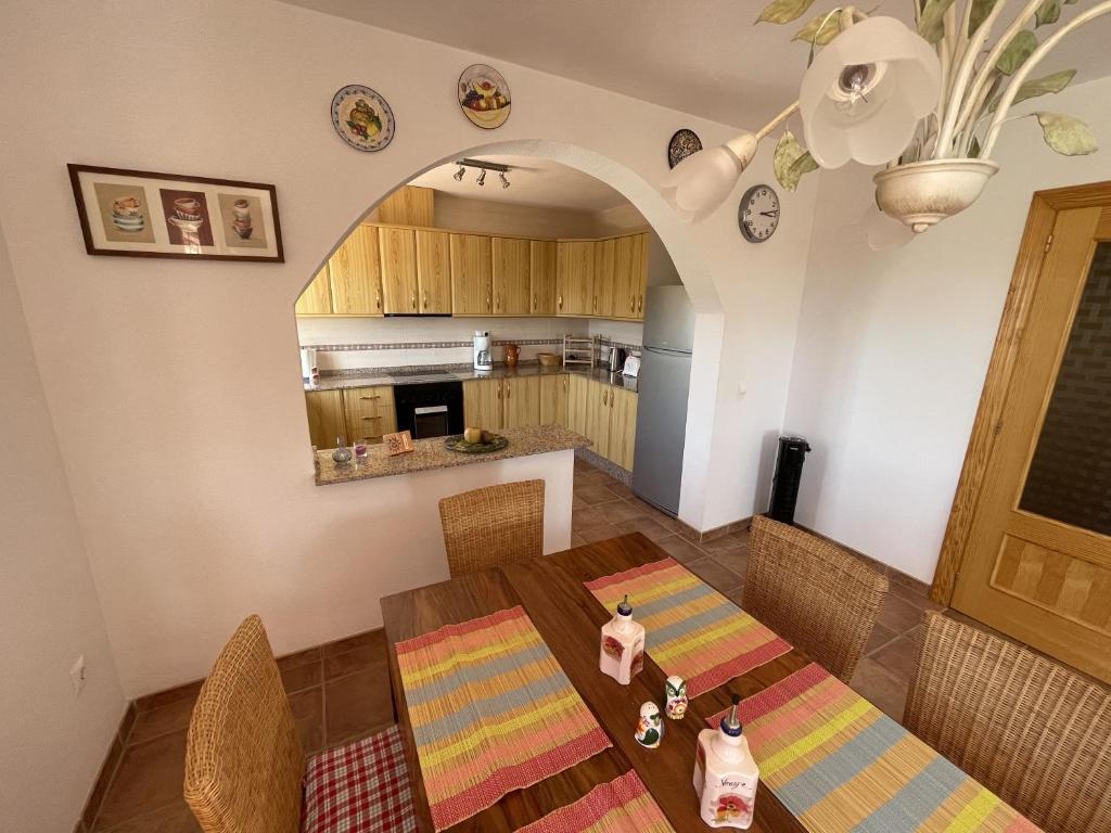 una cucina e una sala da pranzo con tavolo e sedie di Villa Buena Vista a San Vicente del Raspeig