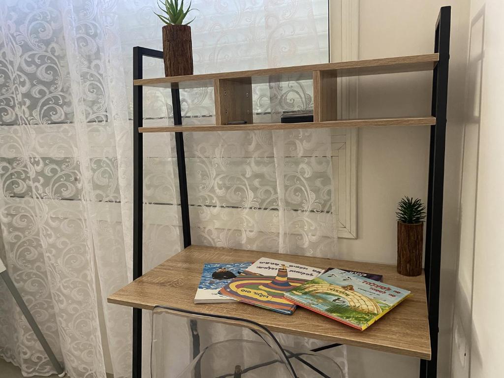 una mesa con una estantería y algunas revistas en ella en וילה בגליל Vila Galilee, en Shadmot Devora