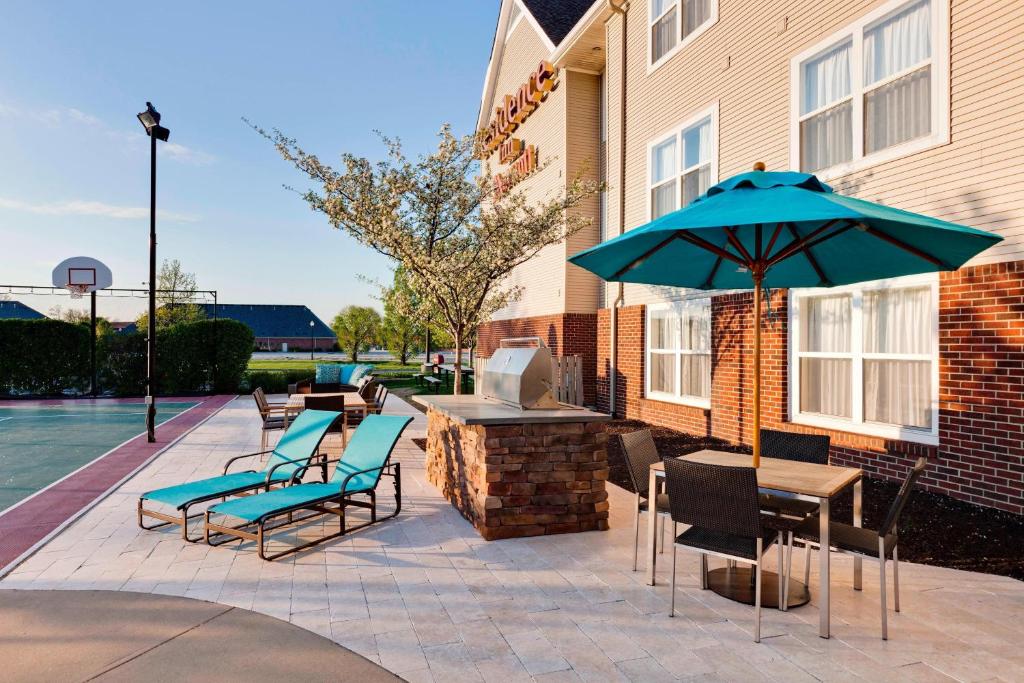 a patio with a table and chairs and an umbrella at Residence Inn Indianapolis Fishers in Fishers