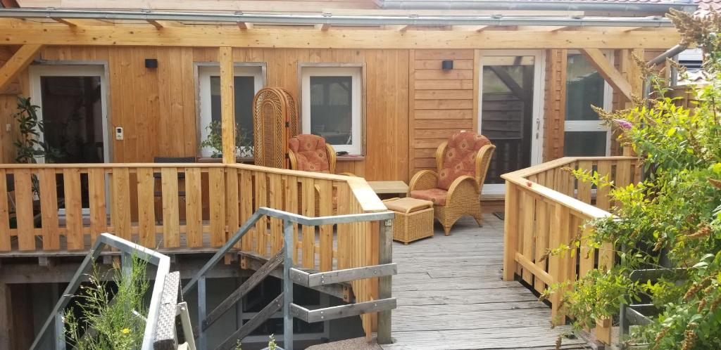 een houten terras met stoelen en een huis bij Alte Scheune in Mossautal