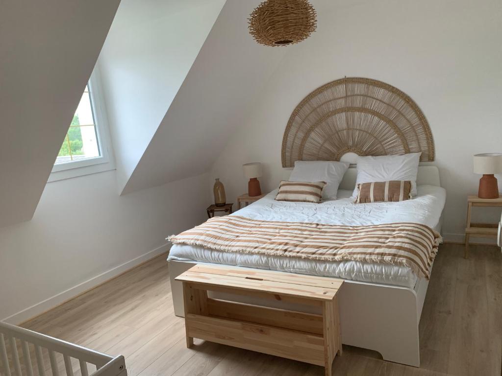 - une chambre avec un grand lit et une table en bois dans l'établissement Gîte La Bourrelière - Spa Salle de jeux Barbecue Beauval, à Châtillon-sur-Cher