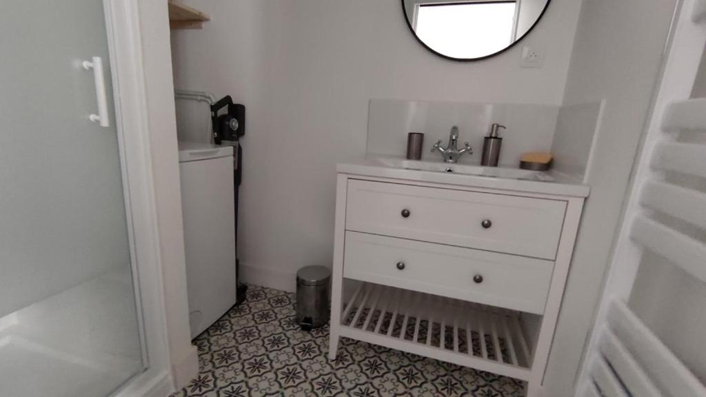 a white bathroom with a sink and a mirror at Le Tréville Grand Studio Cosy 32M2 in Rochefort