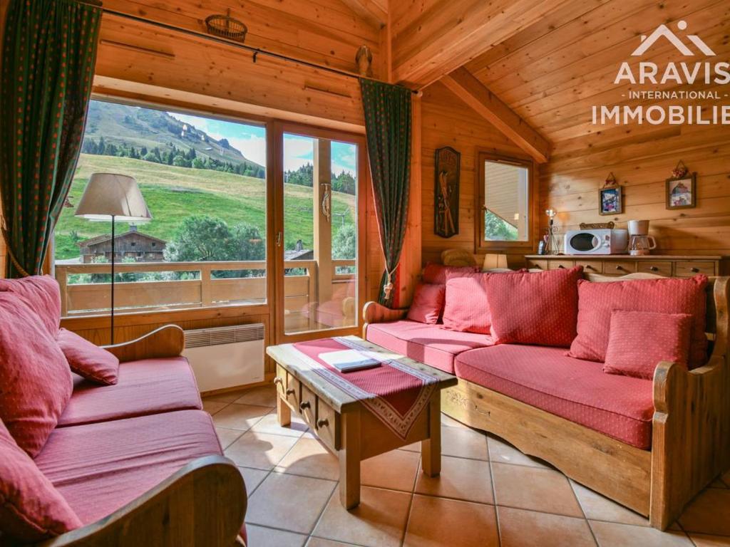 a living room with red couches and a large window at Appartement Le Grand-Bornand, 4 pièces, 8 personnes - FR-1-391-92 in Le Grand-Bornand