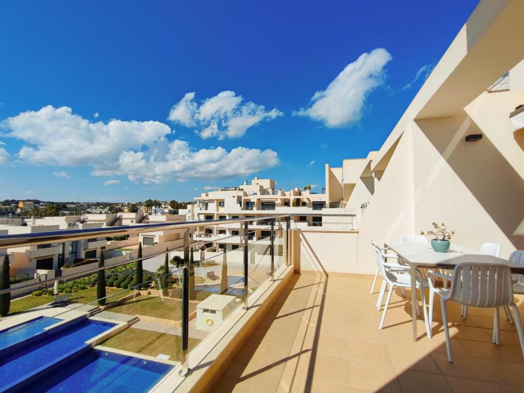 een balkon met een tafel en stoelen in een gebouw bij Apartamento con solarium en Jardines de Montesolana in Alicante