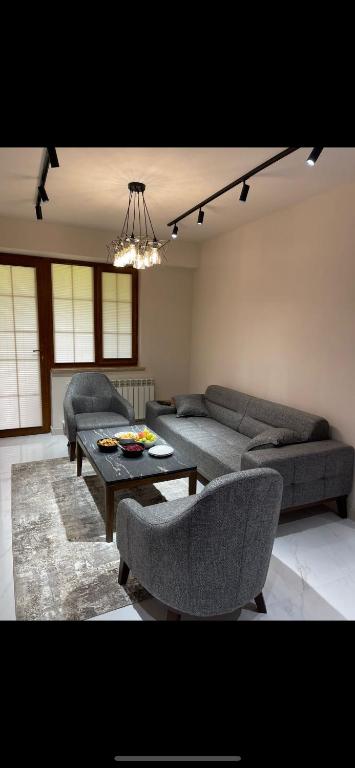 ein Wohnzimmer mit einem Sofa, einem Tisch und Stühlen in der Unterkunft Apartment VR home hilly side in Zaghkadsor