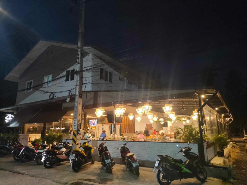 een groep motorfietsen geparkeerd voor een restaurant bij Guesthouse and Restaurant Ratatouille in Baan Tai