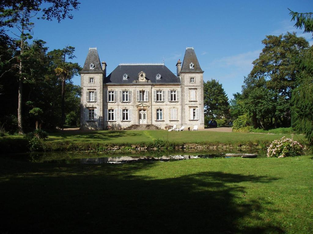 an old castle with a pond in front of it at Chateau des poteries in Fresville