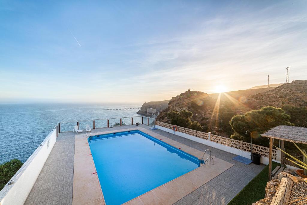 a swimming pool with a view of the ocean at Los acantilados in Almería
