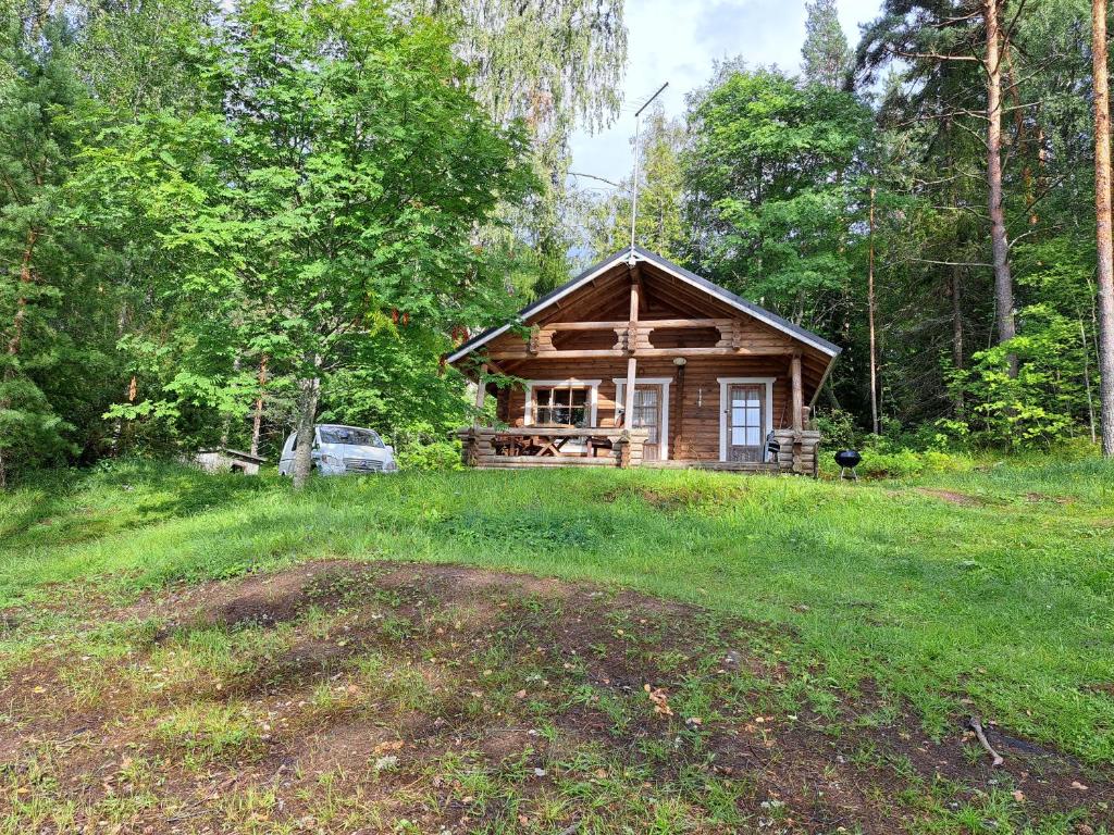 a log cabin in the middle of a field at Rantamökki Naava in Hämeenlinna