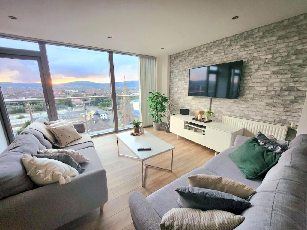 a living room with two couches and a tv at Pass the Keys Stunning Penthouse with Balcony Sunset Views in Belfast