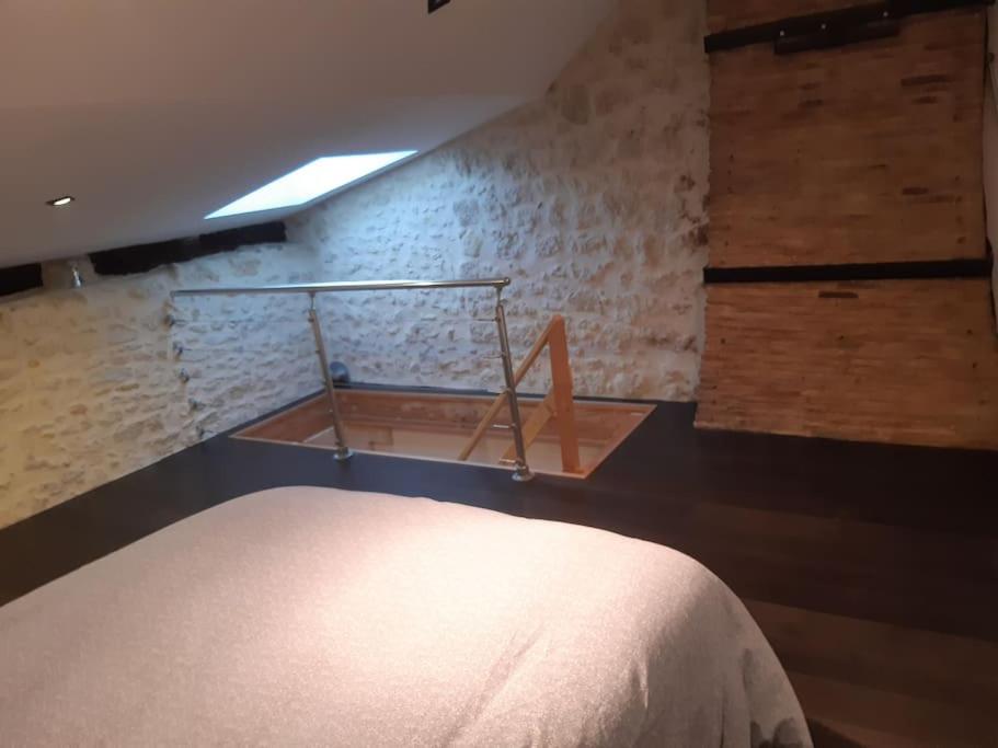 a bedroom with a bed and a wall at Le Petit Nid in Saint-Loubès