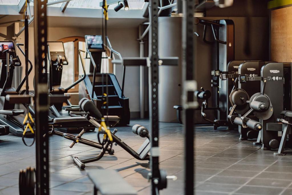 un gimnasio con un montón de equipos de ejercicios en Alpina Alpendorf en Sankt Johann im Pongau