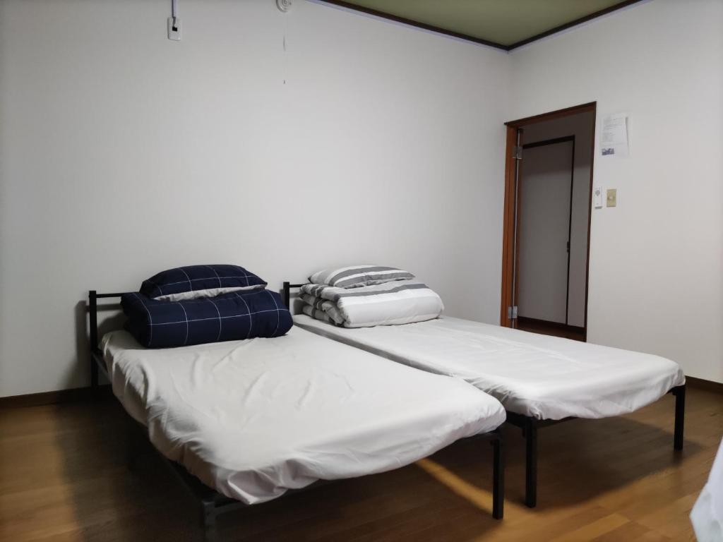 two beds sitting next to each other in a room at 和室+洋室+日本酒飲放題/Premier Guest House 