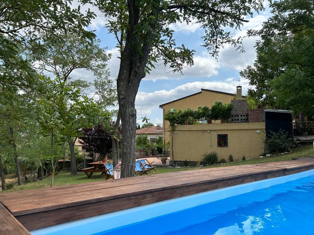 een zwembad met een boom naast een huis bij Appartamento Bellavista in Saline