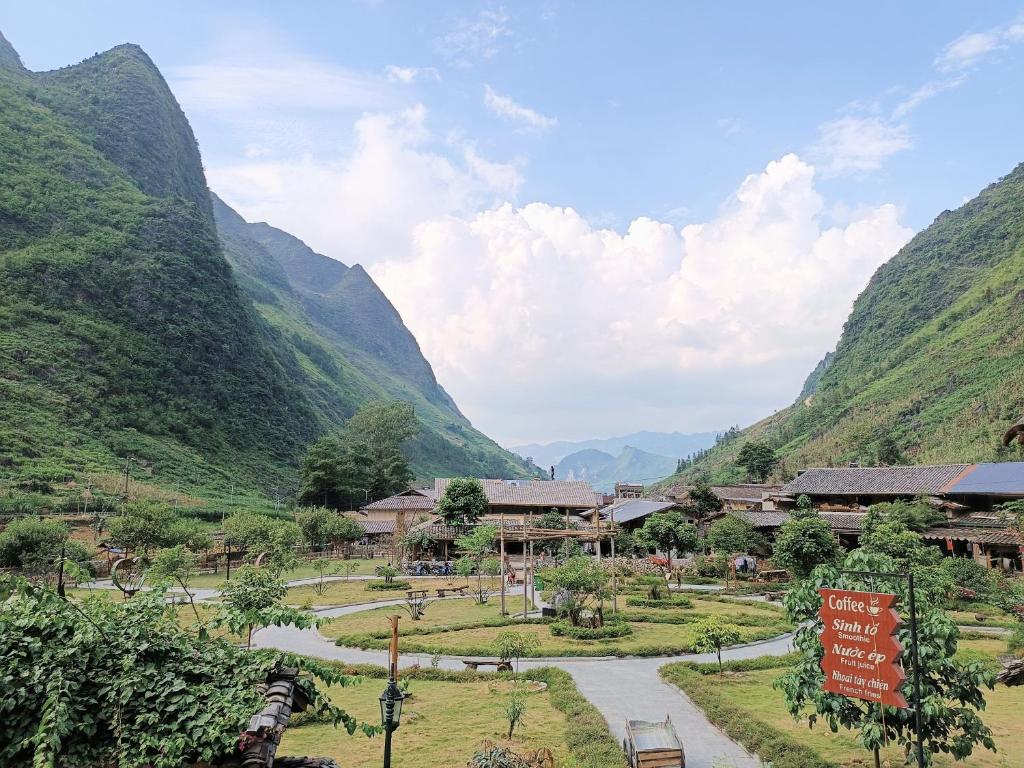 a village in a valley with mountains in the background at A Kiệt Homestay in Mèo Vạc