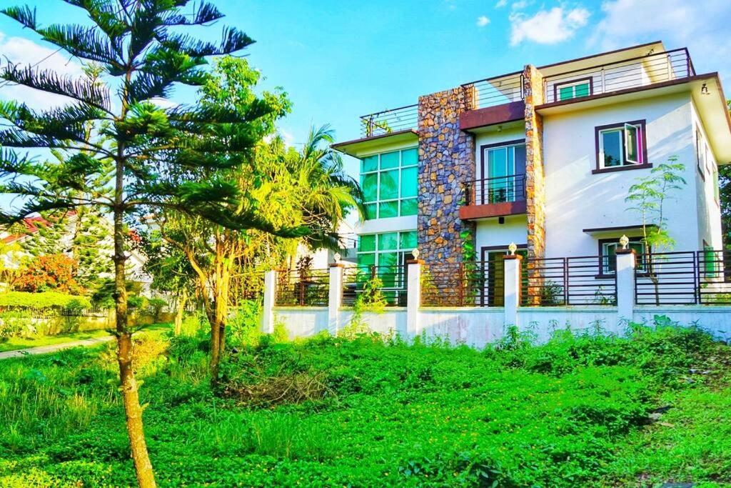 una casa con un árbol delante de ella en Melia's House Tagaytay - Nature Home for Rent, en Tagaytay