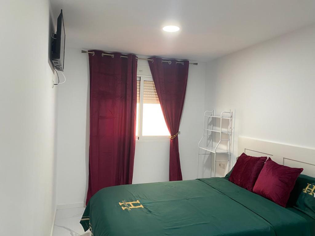 Un dormitorio con una cama verde y una ventana en Alojamiento con habitaciones dobles y baño privado, en Valencia