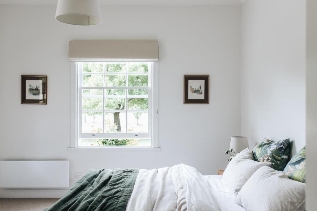 biała sypialnia z łóżkiem i oknem w obiekcie Chatsworth Tasmania w mieście Longford
