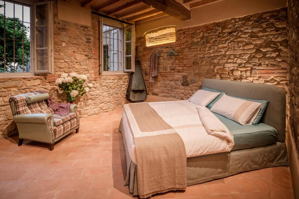 a bedroom with a bed and a stone wall at Corte Finzi in Sala Baganza
