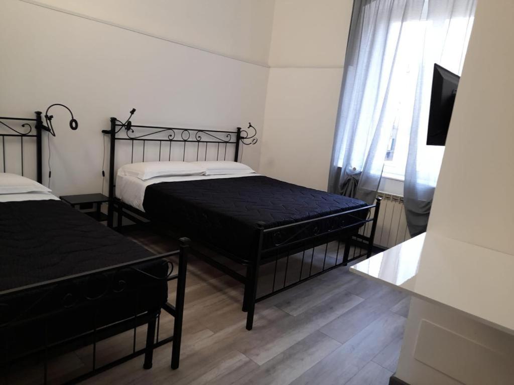 a bedroom with two beds and a flat screen tv at Affitta Camere La Turandot in Genova