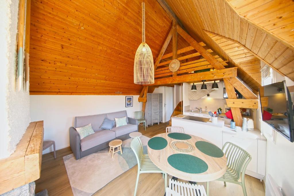 una sala de estar con una mesa y un sofá en Marée Haute et Marée Basse - 1 Appartement et 1 Studio proche de la plage, en Barneville-Carteret
