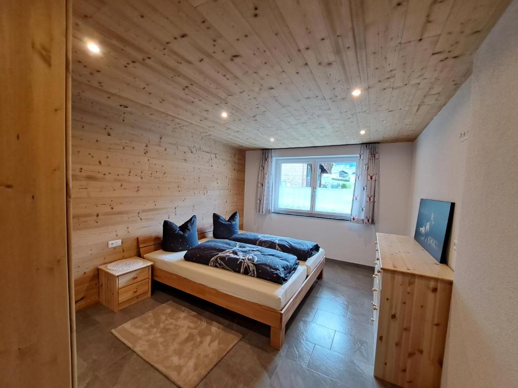 um quarto com uma cama num quarto de madeira em Rovina Apartments em Gaschurn