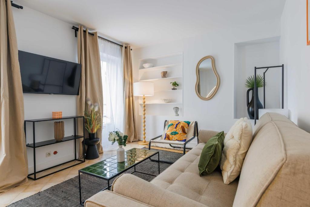 uma sala de estar com um sofá e uma televisão em Amazing and cosy apartment rue des Petites Ecuries 4P1BR em Paris