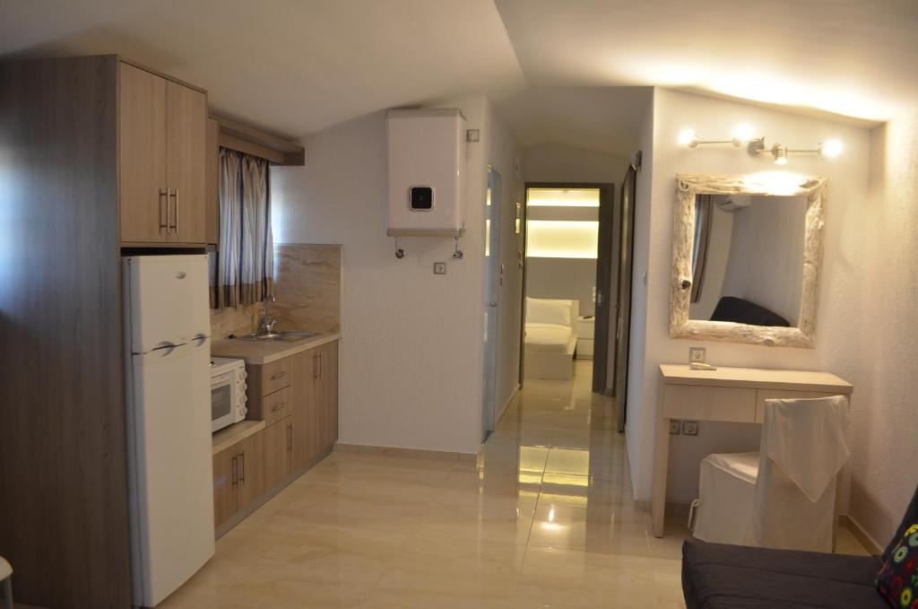 a kitchen with a white refrigerator and a sink at Ammos Apartments in Glida