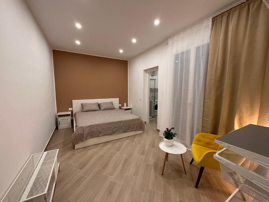 1 dormitorio con 1 cama y 1 silla amarilla en Casa AnnaBella, en Trapani