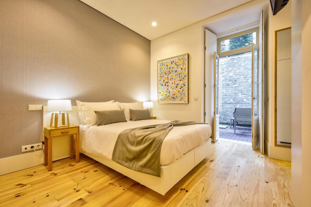 ein Schlafzimmer mit einem großen Bett und einem Fenster in der Unterkunft Avenue Garden in Coimbra