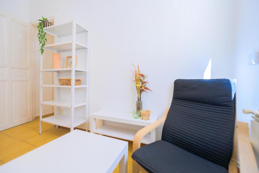 a living room with a chair and a book shelf at For You Rentals Encantadora vivienda de 3 habitaciones en Madrid AME49 in Madrid