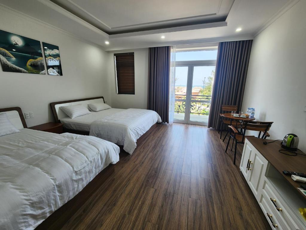 a hotel room with two beds and a balcony at Starfish house in Nghi Xuân