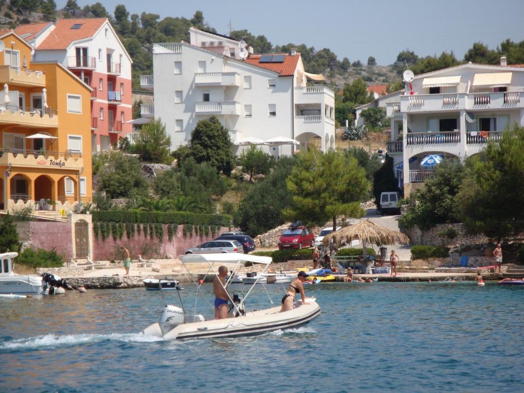 zwei Personen auf einem Boot in einem Wasserkörper in der Unterkunft Apartments Ani in Zaboric