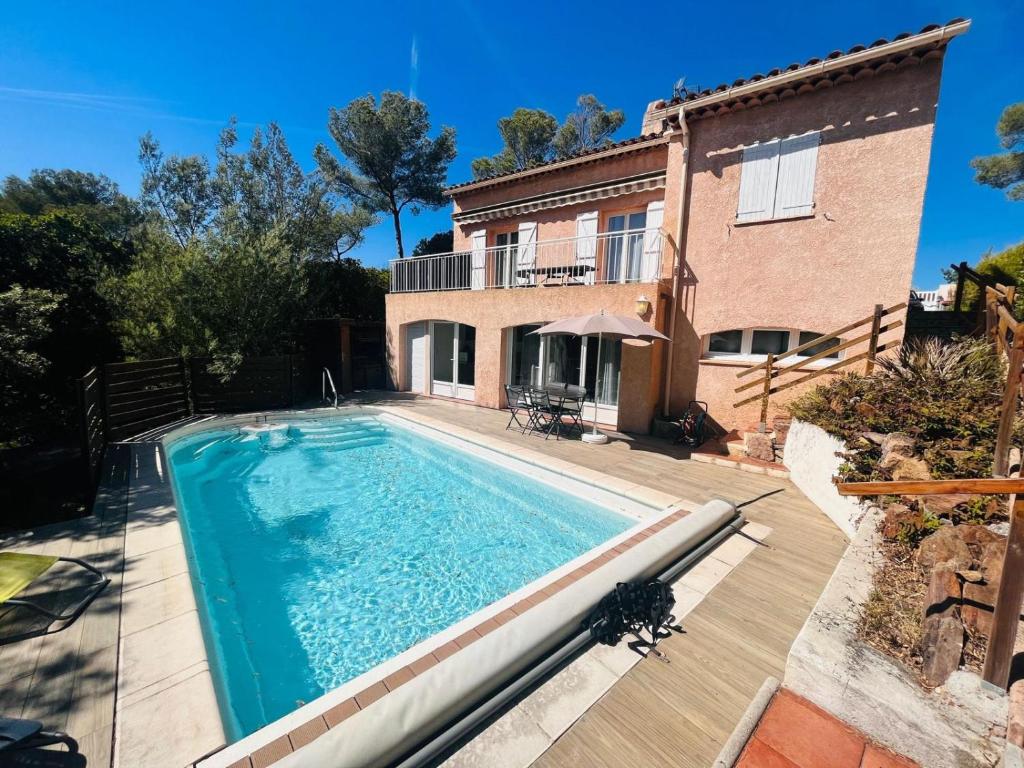 a swimming pool in front of a house at Escale Douceur d'Estérel in Saint-Raphaël