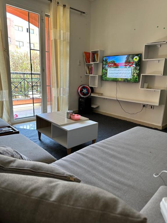 uma sala de estar com 2 camas e uma televisão de ecrã plano em غرفة في منزل هادئ وأنيق em Sheikh Zayed