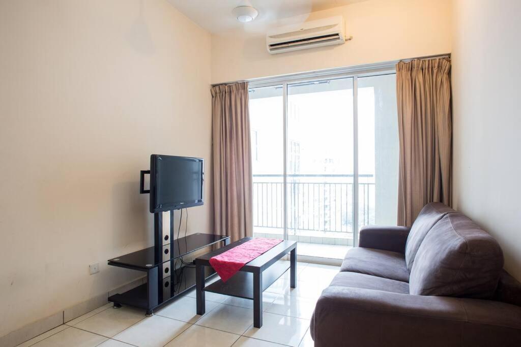 uma sala de estar com um sofá e uma televisão em Cosy 2Bed2Bathroom at Casa Suites em Petaling Jaya
