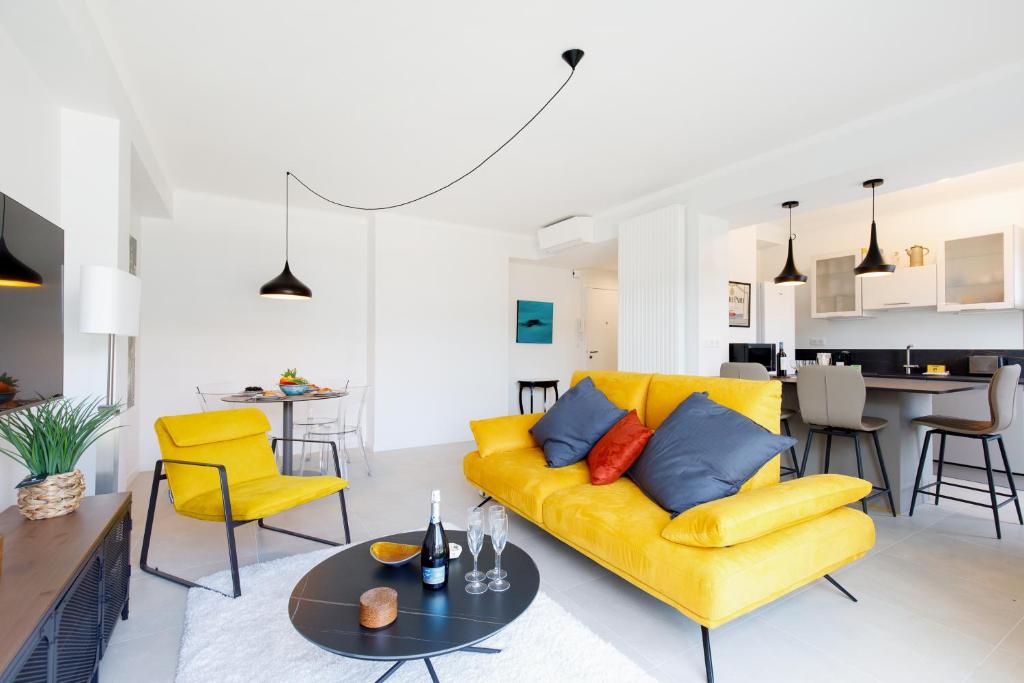 un salon avec un canapé jaune et une table dans l'établissement Wam YourHostHelper, à Cannes
