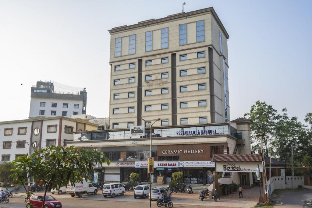 un edificio alto en una calle de la ciudad con coches aparcados en The Sky Imperial Hotel The Maison, en Anand