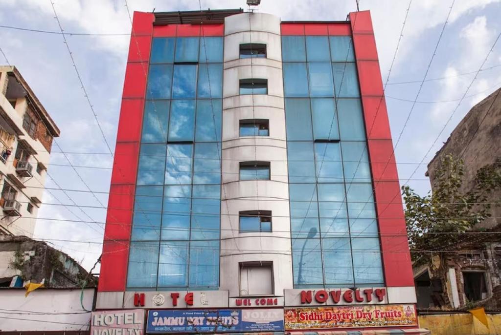 a tall building with glass windows on a street at Hotel Novelty in Jammu