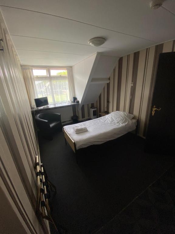 Aalden的住宿－Het Wapen van Aelden，小房间设有一张床和一把椅子