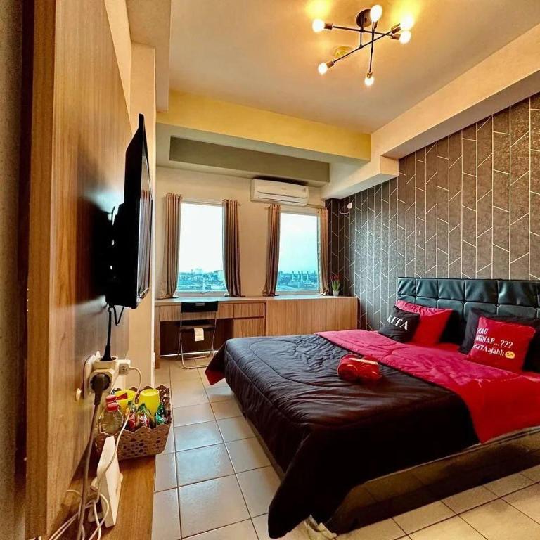 1 dormitorio con 1 cama grande con almohadas rojas en Patraland Urbano by Red Promo, en Bekasi