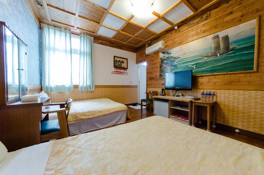 a hotel room with two beds and a television at Donglifang B&amp;B in Guanshan