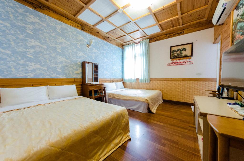 a hotel room with two beds and a tv at Donglifang B&amp;B in Guanshan
