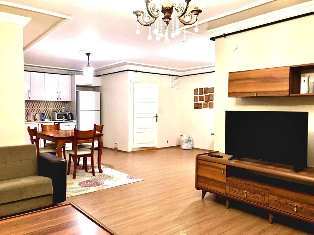 a living room with a television and a dining room at Halic apart hotel in Yalova