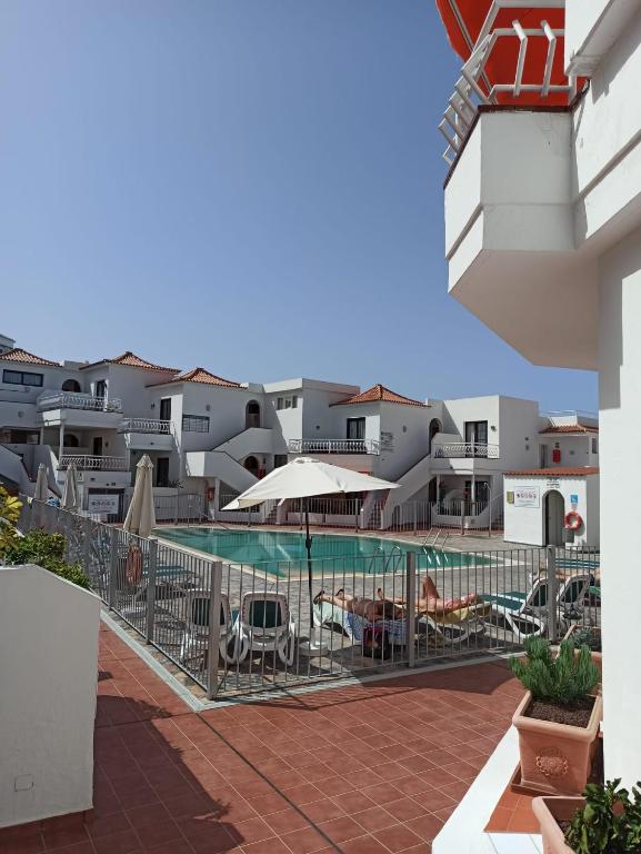 a view of a swimming pool with chairs and umbrellas at Antonio Apartment in Los Cristianos