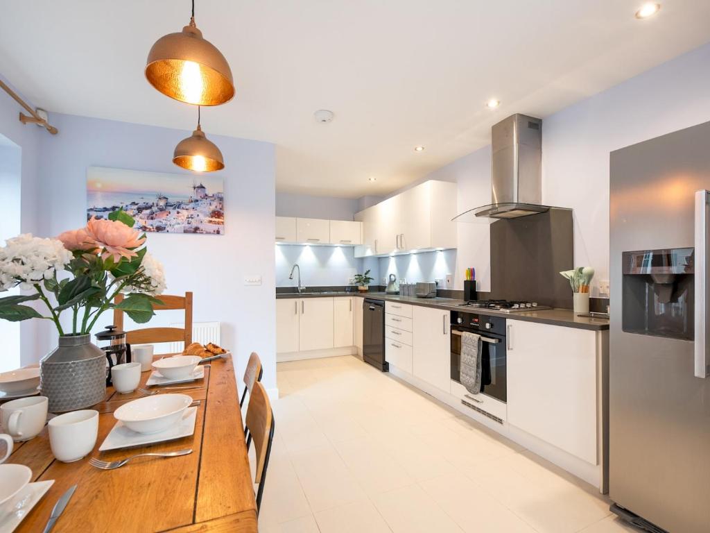 uma cozinha com uma mesa de madeira e uma sala de jantar em Pass the Keys Central Marlow townhouse with private parking em Marlow